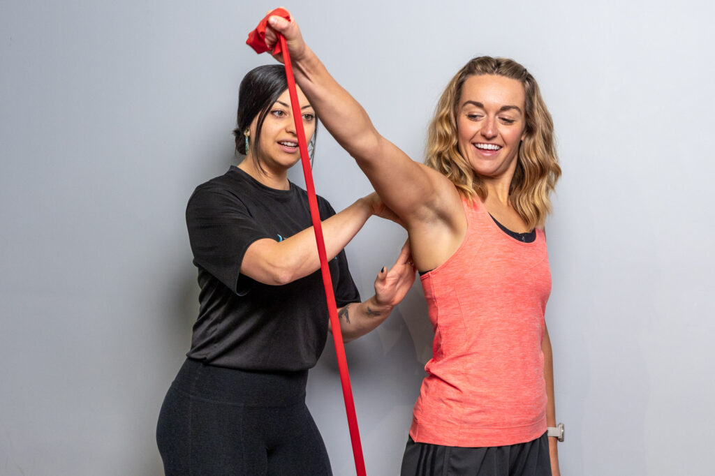 A female patient undergoes rehabilitation services near Wicker Park using a resistance band under the guidance of a Balanced Flow Wellness provider.