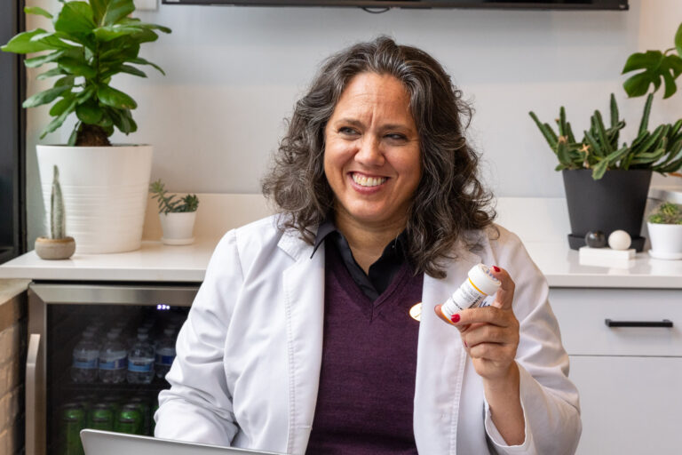 A trusted medical provider at Balanced Flow Wellness holding up medication for Hormone Optimization in Chicago