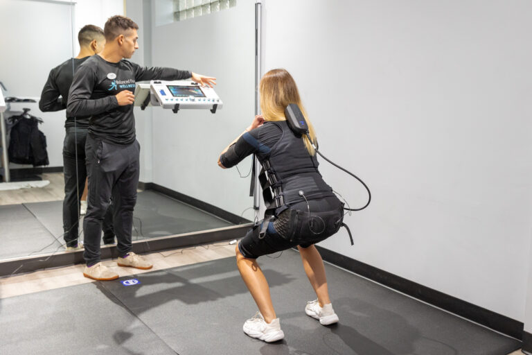 A Balanced Flow trainer taking a patient through a workout at their medical gym near Bucktown.