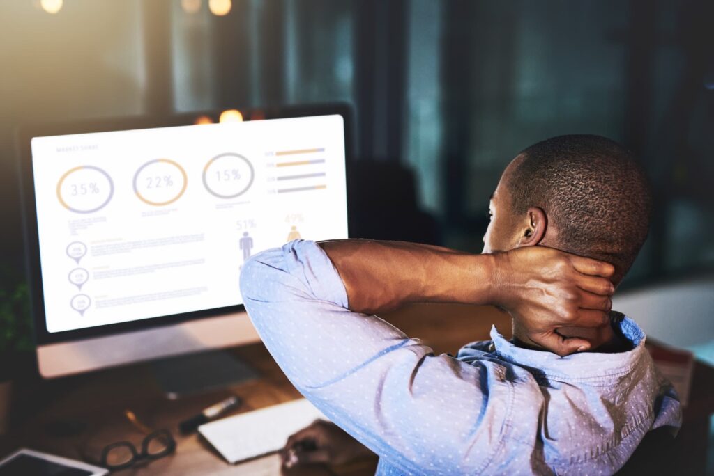 A POC manstaring at a computer screen with data percentages, rubbing his sore neck, and thinking about the Best Shoulder Exercises Near Wicker Park.