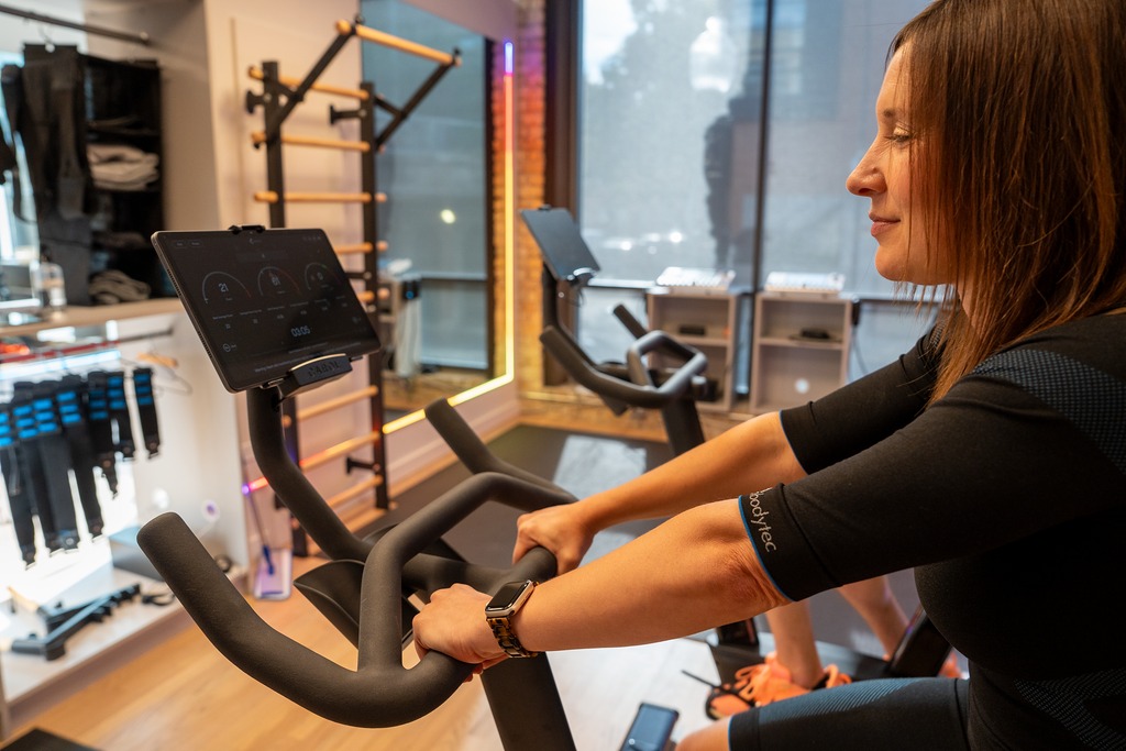 Side view of a client riding the CAROL bike in the MedGym training studio